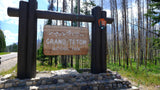 Grand Teton National Park entrance sign. Start your rv rental journey to this stunning park, surrounded by trees.