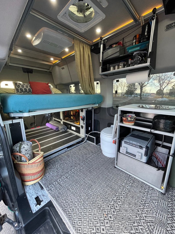 Experience van life in this RV rental! Elevated bed, compact kitchen, toilet, and smart storage fill this cozy camper van.