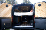 Open rear doors of an RV rental camper van, revealing its custom wood interior with a bed and storage space.