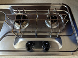 RV rental's compact stainless steel two-burner cooktop with integrated sink, ready for travel adventures.