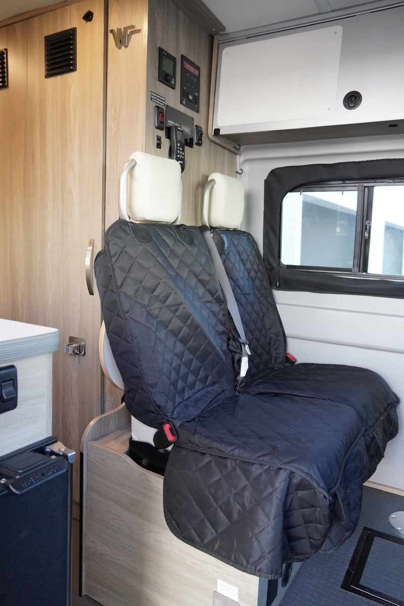  and a cozy bed area.|Cozy RV rental interior: two seats with black covers — photo 7