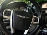 Interior view of a Chrysler minivan's steering wheel and dashboard controls, perfect for an RV rental road trip.
