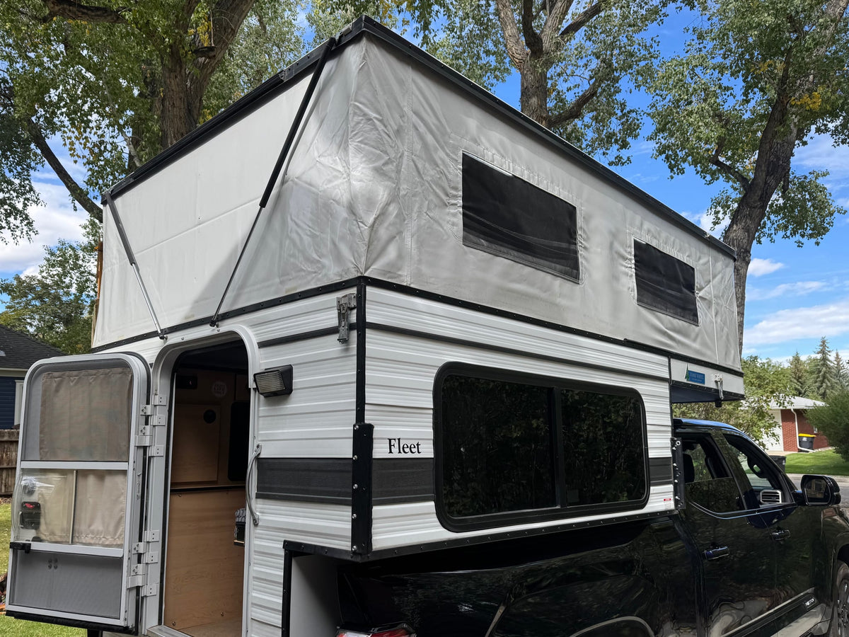  and cabinet storage from the open door.|Pop-top truck camper for RV rental — photo 7