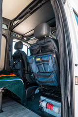RV rental interior: practical seat-back organizers, fire extinguisher, and cozy blanket for efficient, safe travels.