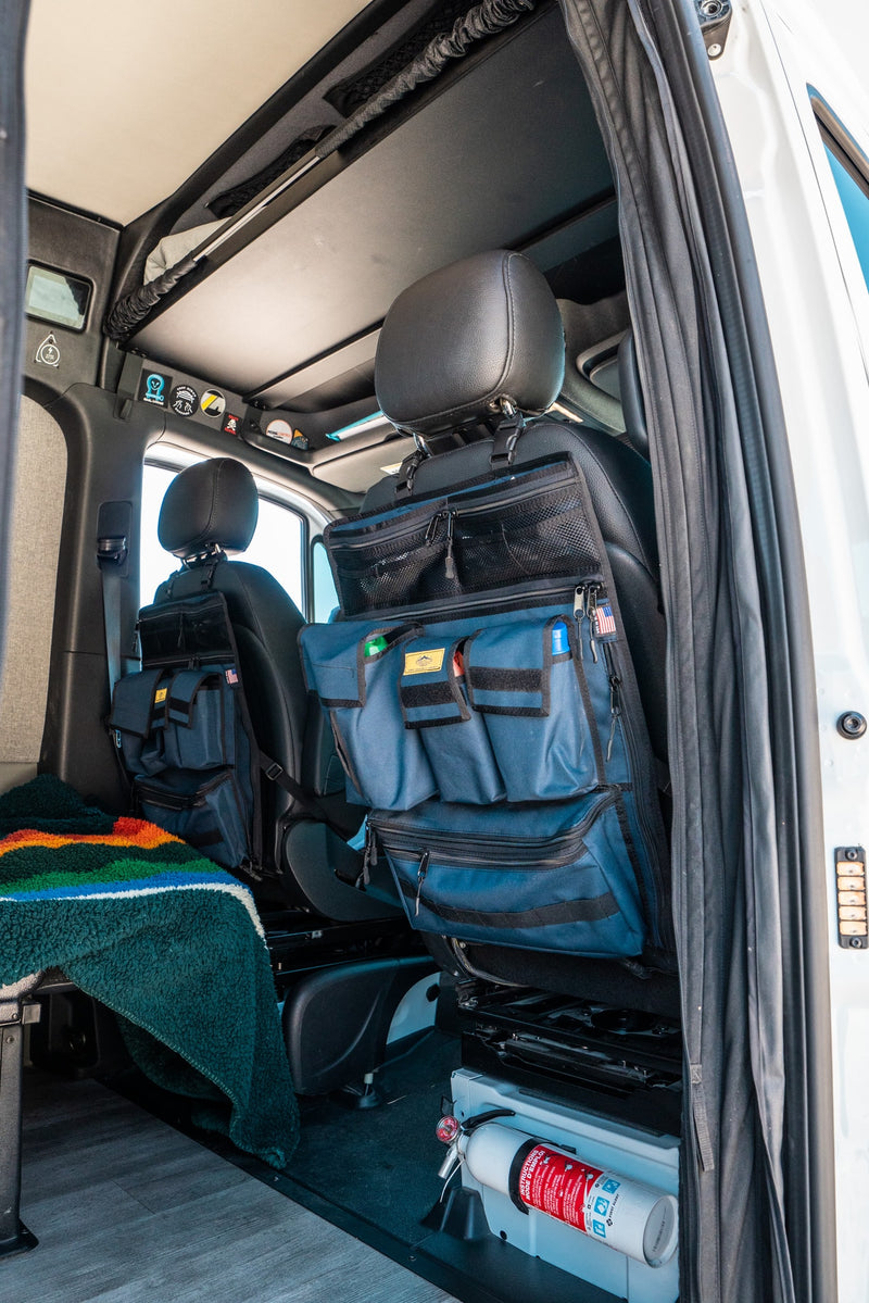 RV rental interior: practical seat-back organizers, fire extinguisher, and cozy blanket for efficient, safe travels. — photo 13