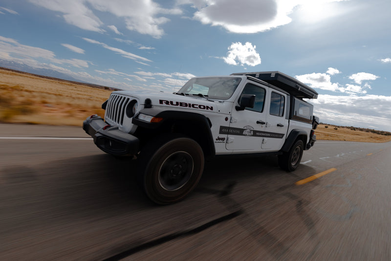 White Jeep Gladiator RV rental with rooftop tent on an open road. Ideal for adventure travel & overlanding. — photo 7