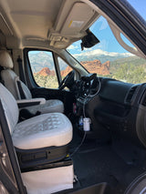 Comfortable RV rental interior with quilted seats and a stunning view of snowy mountains and red rock formations for your adventure.