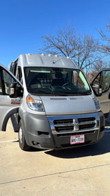 Silver Ram ProMaster camper van, an RV rental, with doors open in a sunny Texas lot.