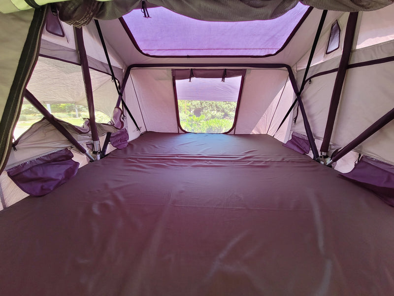 Experience comfort in this spacious rooftop tent interior, ideal for your next RV rental trip. Features a large mattress and scenic window views. — photo 11