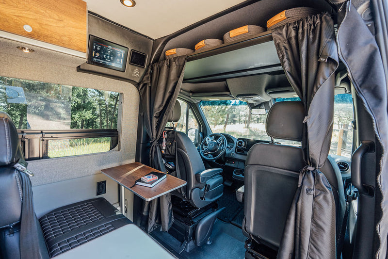  table with wine.|Rear view of a grey Storyteller RV rental with a star-patterned gear rack and bike carrier — photo 5