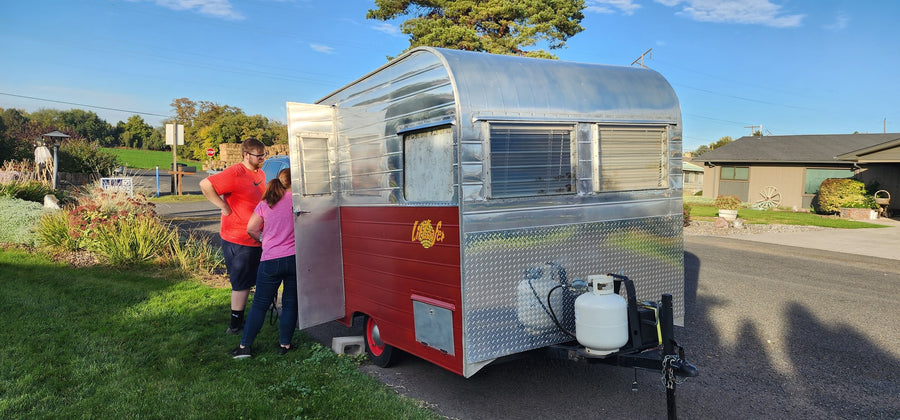  off-grid water storage.|Open cabinet in an RV rental with water jugs