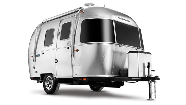 A sleek, silver Airstream travel trailer, perfect for your next rv rental adventure. Iconic rounded design with large tinted windows.