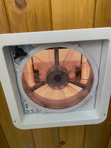 Inside an RV rental: a MaxxAir roof vent fan with its control panel and mesh screen, installed in a wooden ceiling.