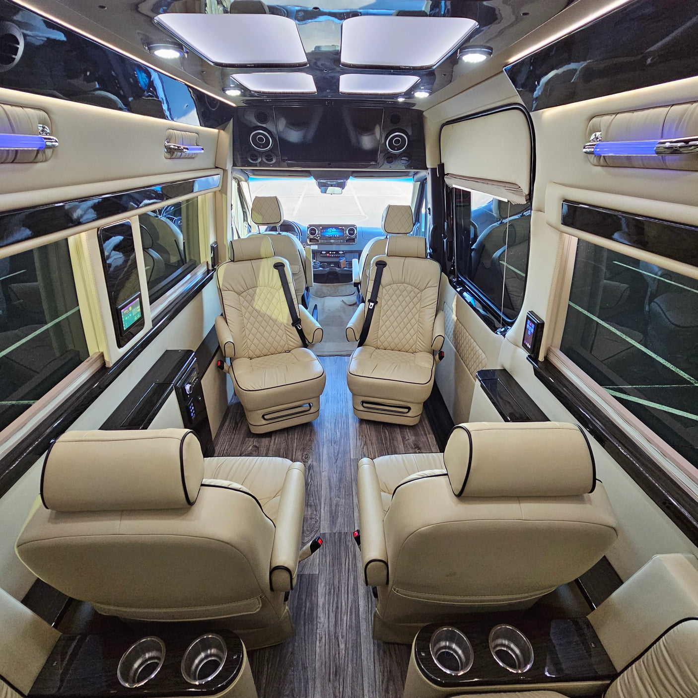 Luxurious RV rental interior with plush cream leather seats, elegant wood trim, and ambient lighting.