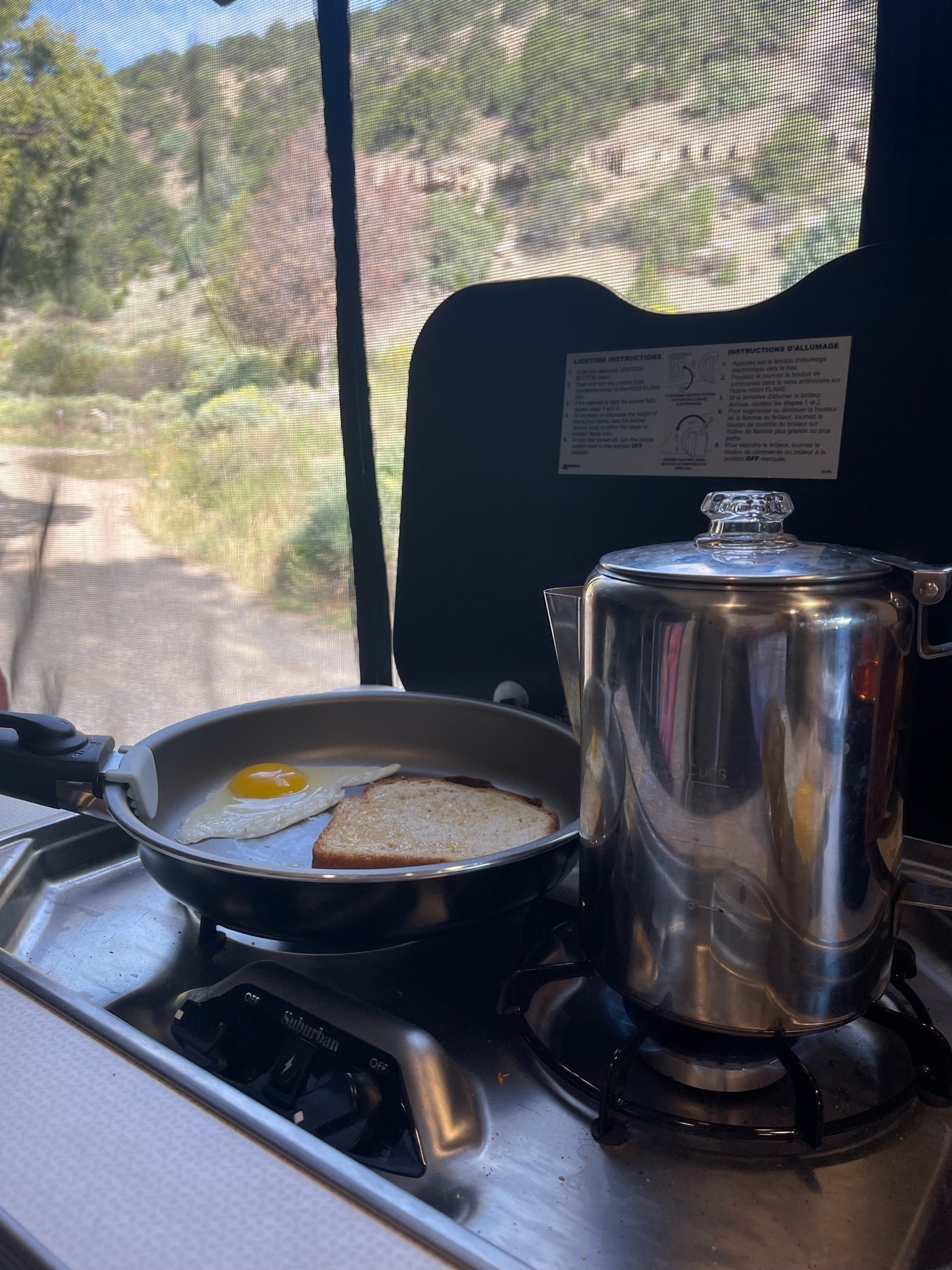 Breakfast cooking in an RV rental: egg, toast, and coffee on a camping stove, with a scenic outdoor view. — photo 10