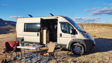 Enjoy your next adventure with an RV rental! This Ram ProMaster camper van is set up for desert camping with outdoor seating.