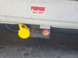 RV rental propane system: yellow fill point cap, ON/OFF switch, and safety warnings. Essential for safe RV operation.