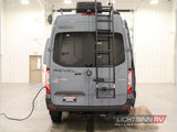 This gray Winnebago Revel Mercedes Sprinter van, equipped with a ladder, is ready for rv rental adventures.