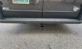 An RV rental's rear shows a tow hitch and bumper sensors, ready for adventure.