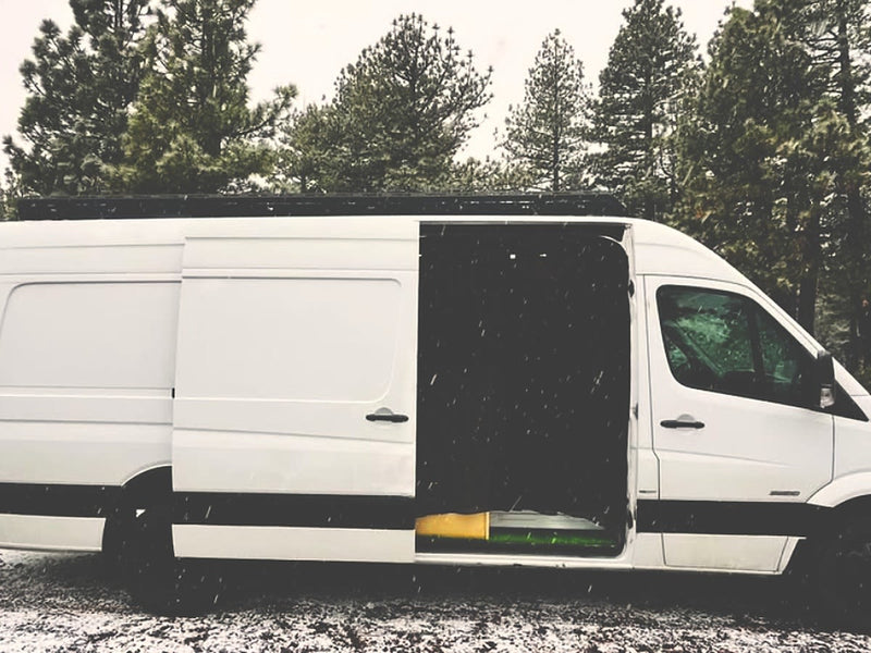  driver's door open in a snowy forest. Ideal for winter adventures and van life.|Adventure-ready rv rental camper van in a snowy forest. Open rear doors reveal a cozy — photo 7