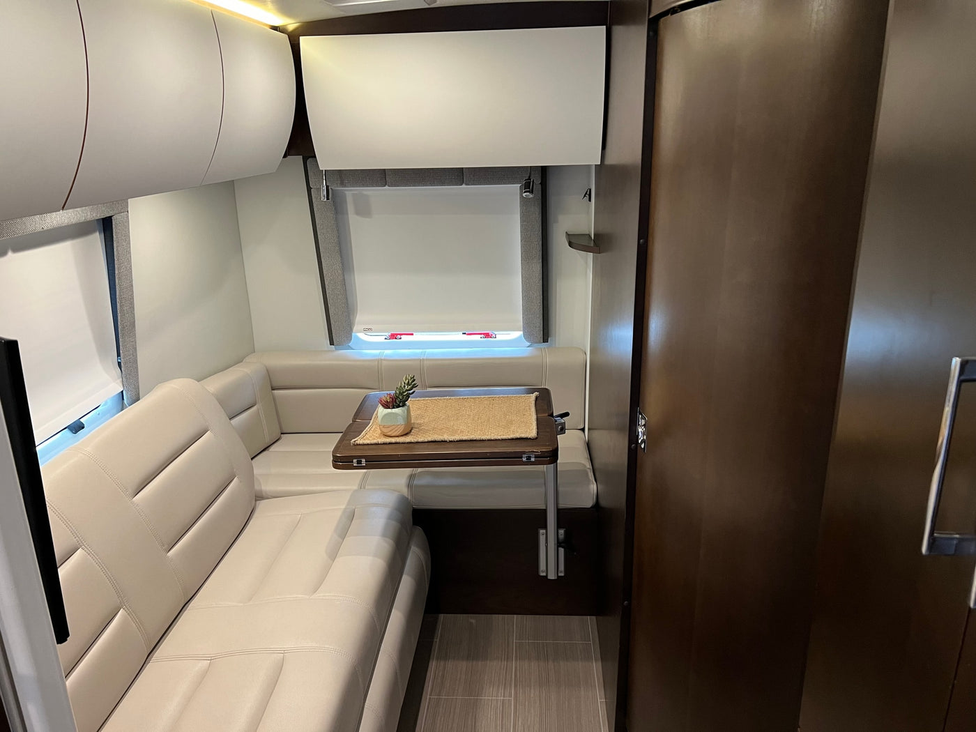  and a view outside.|Modern rv rental interior: light leather seating — photo 17
