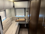 This inviting rv rental features a modern interior with a cozy, U-shaped dinette, table, and overhead storage.