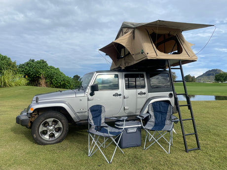 Like an RV rental, this Jeep with a rooftop tent offers outdoor adventure. Camping chairs & cooler await.
