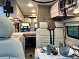 This RV rental offers a compact, bright interior with kitchen, dining area, and panoramic sunset views.