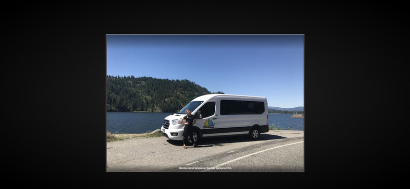Enjoy the outdoors! White Wandervans campervan RV rental parked by a lake, with mountains and a person. — photo 9