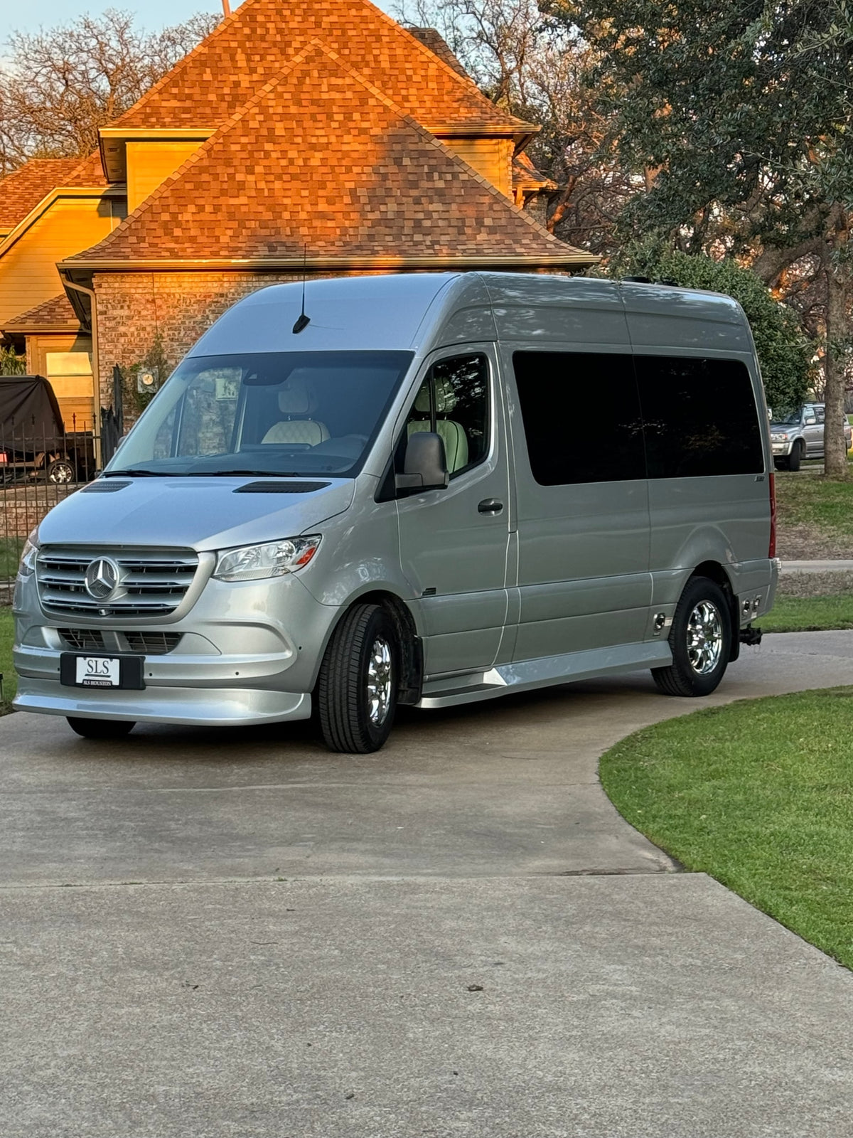 Silver Mercedes-Benz Sprinter luxury RV rental parked on a residential driveway