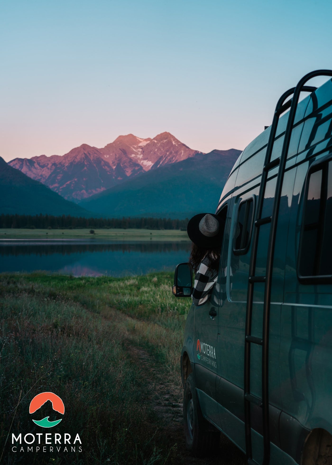  featuring a sleek shower stall on the right and a comfortable bedroom with a bed & window beyond.|View of a compact RV rental kitchen featuring a light wood countertop — photo 3
