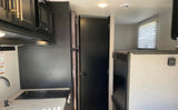 Explore this RV rental's interior: kitchen with microwave, fridge, sink, stove, plus bunk beds.