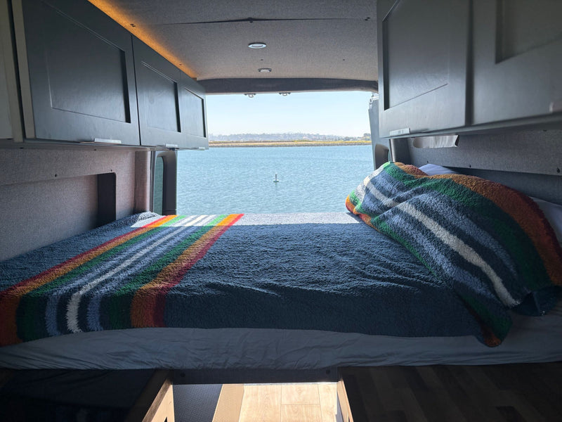  under cloudy skies.|A child sits on a cozy bed in an RV rental — photo 8