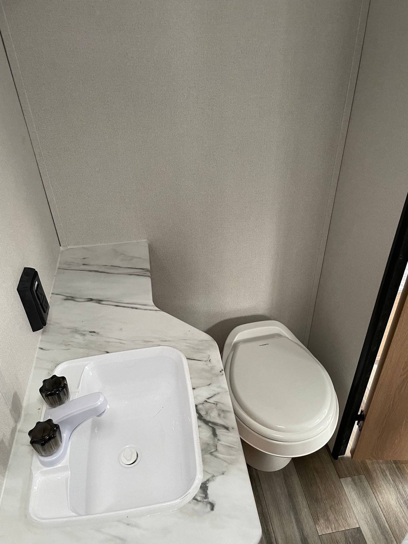 Clean RV rental bathroom with white sink, faucet, marble counter, and Dometic toilet. Practical for compact living. — photo 5