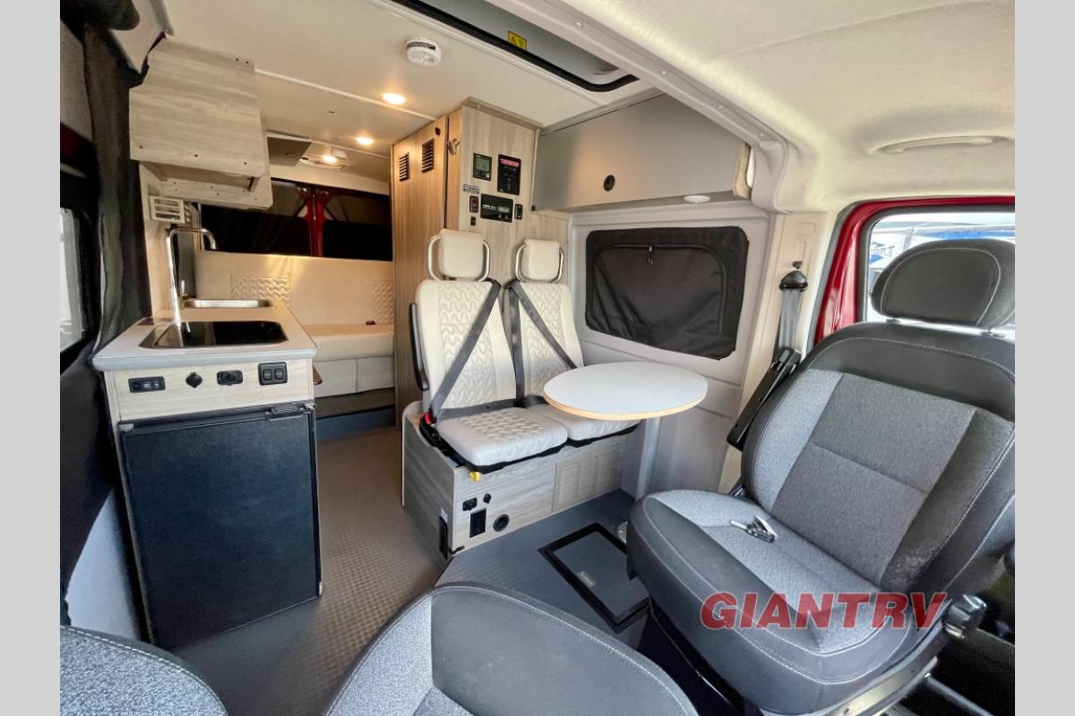  and a dinette with textured white seats.|RV rental interior: galley with a 2-burner stove — photo 9