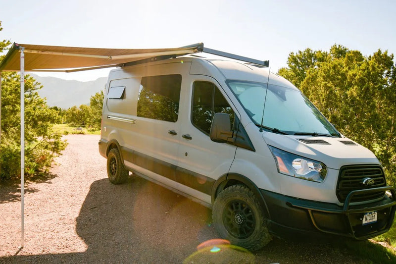  and a compact kitchen area.|RV rental camper van interior. Features cozy bed looking out to forest — photo 6