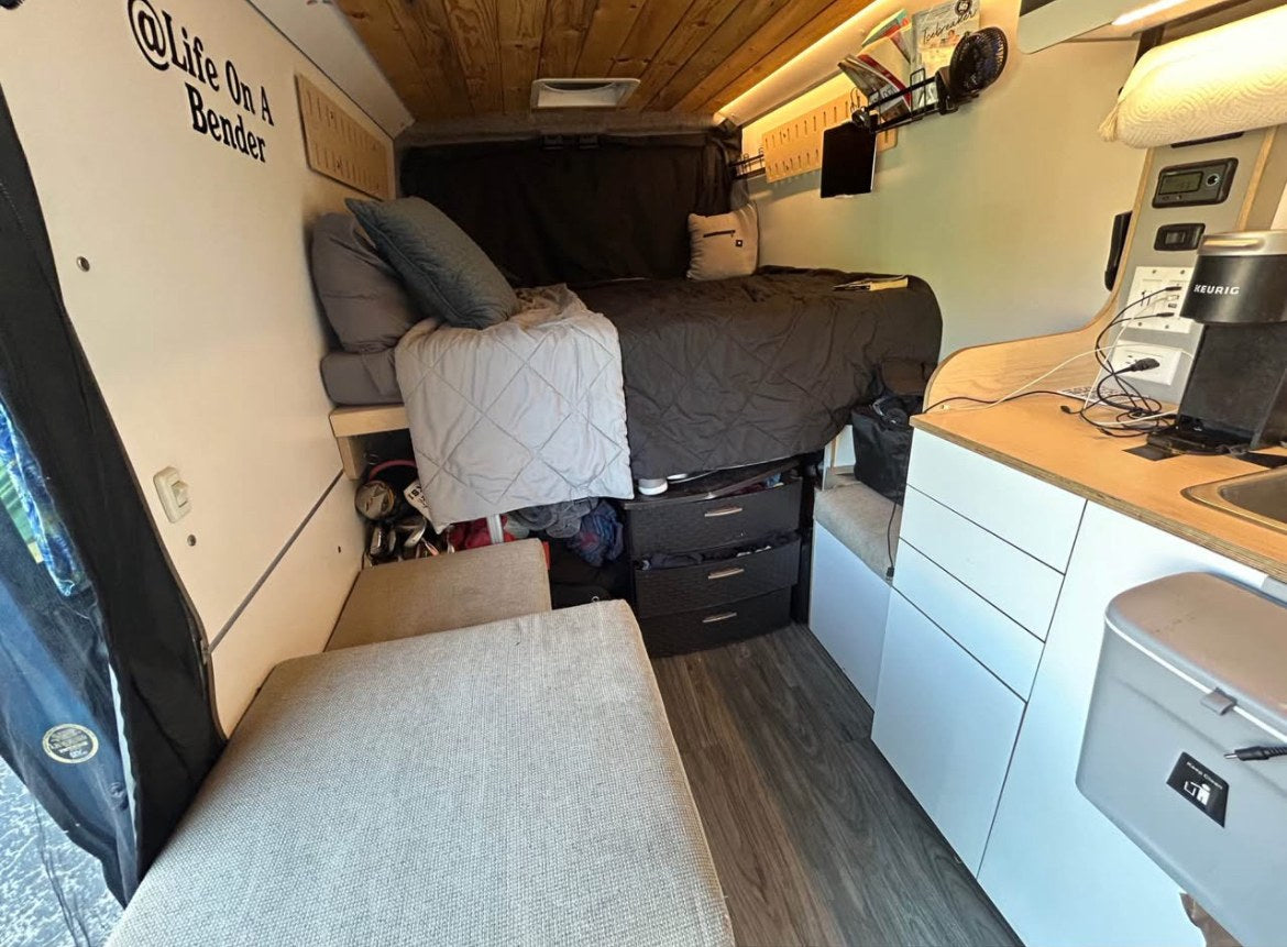This RV rental features a comfortable bed, smart storage solutions, and a compact kitchen. Ideal for mobile living. — photo 2