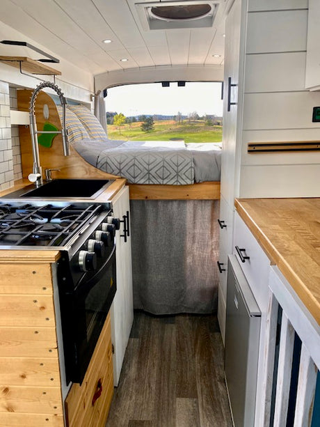Experience cozy road trips in this RV rental! Features a fully equipped kitchen, elevated bed, and scenic views.