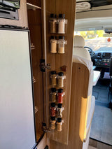 Spices organized on an RV rental cabinet door, maximizing kitchen space for convenient travel.