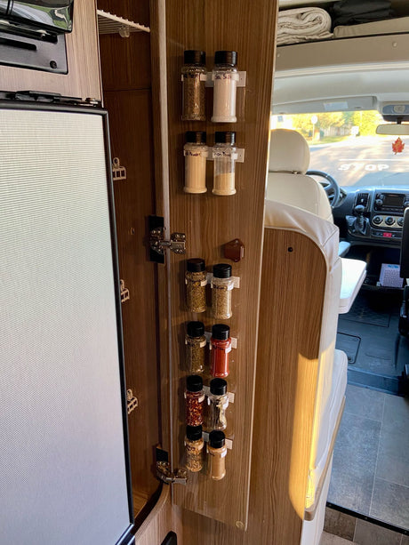 Spices organized on an RV rental cabinet door, maximizing kitchen space for convenient travel.