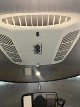 RV rental overhead view: A white AC unit with air vents and Coleman Mach controls for heating and cooling comfort.