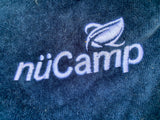 Embroidered nüCamp logo on blue fabric, showcasing quality for your next RV rental.