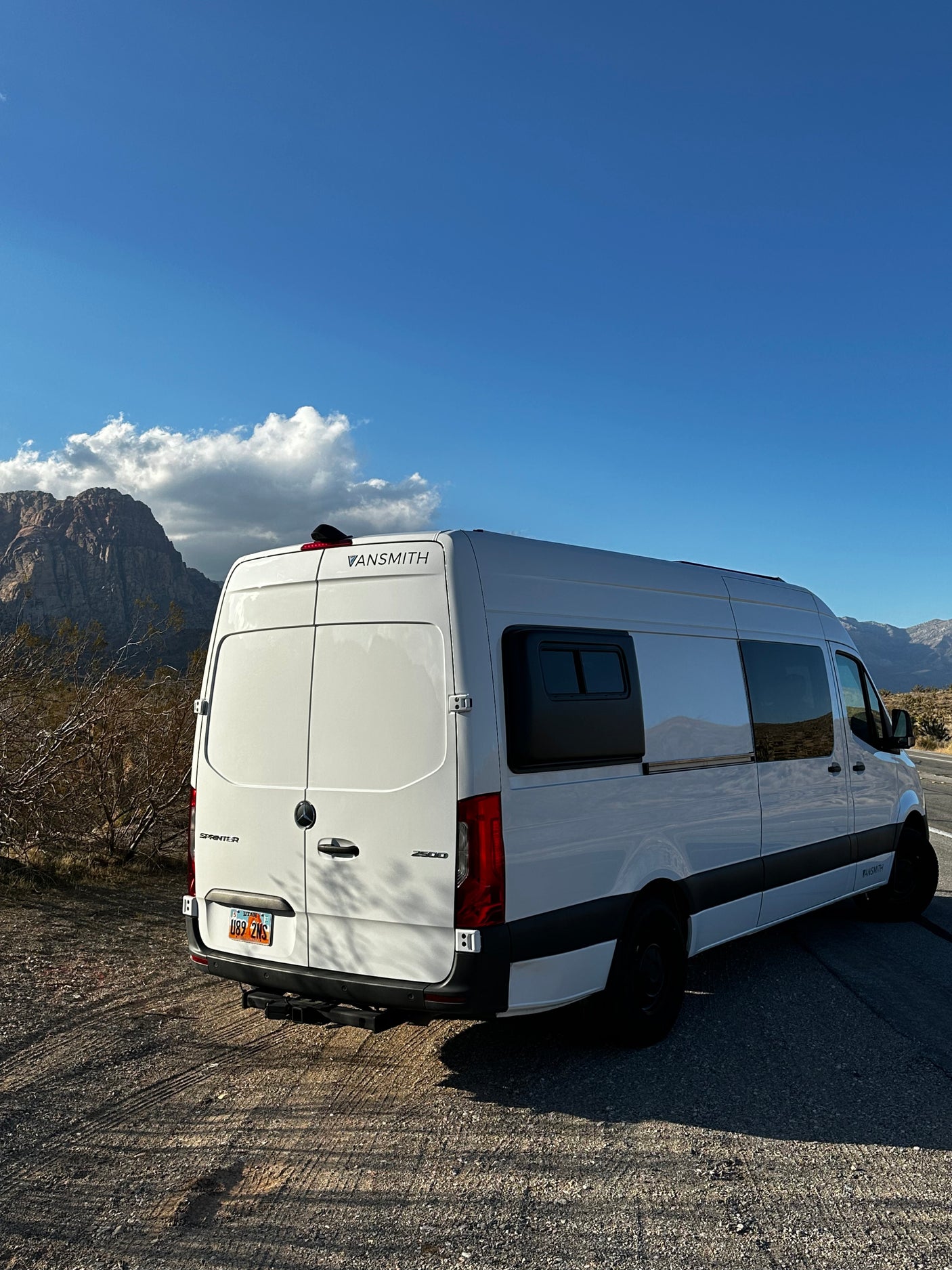 Vansmith Mercedes Sprinter camper van parked with mountains in the background, perfect for an rv rental adventure.