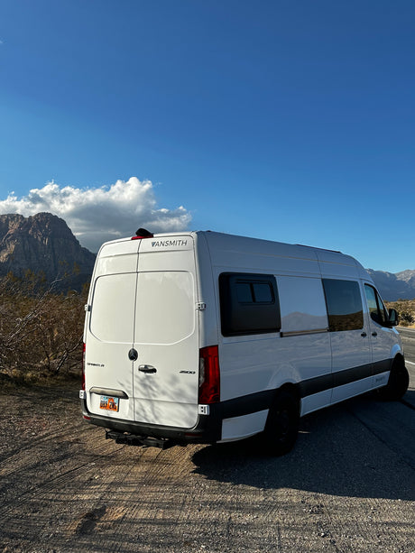 Vansmith Mercedes Sprinter camper van parked with mountains in the background, perfect for an rv rental adventure.