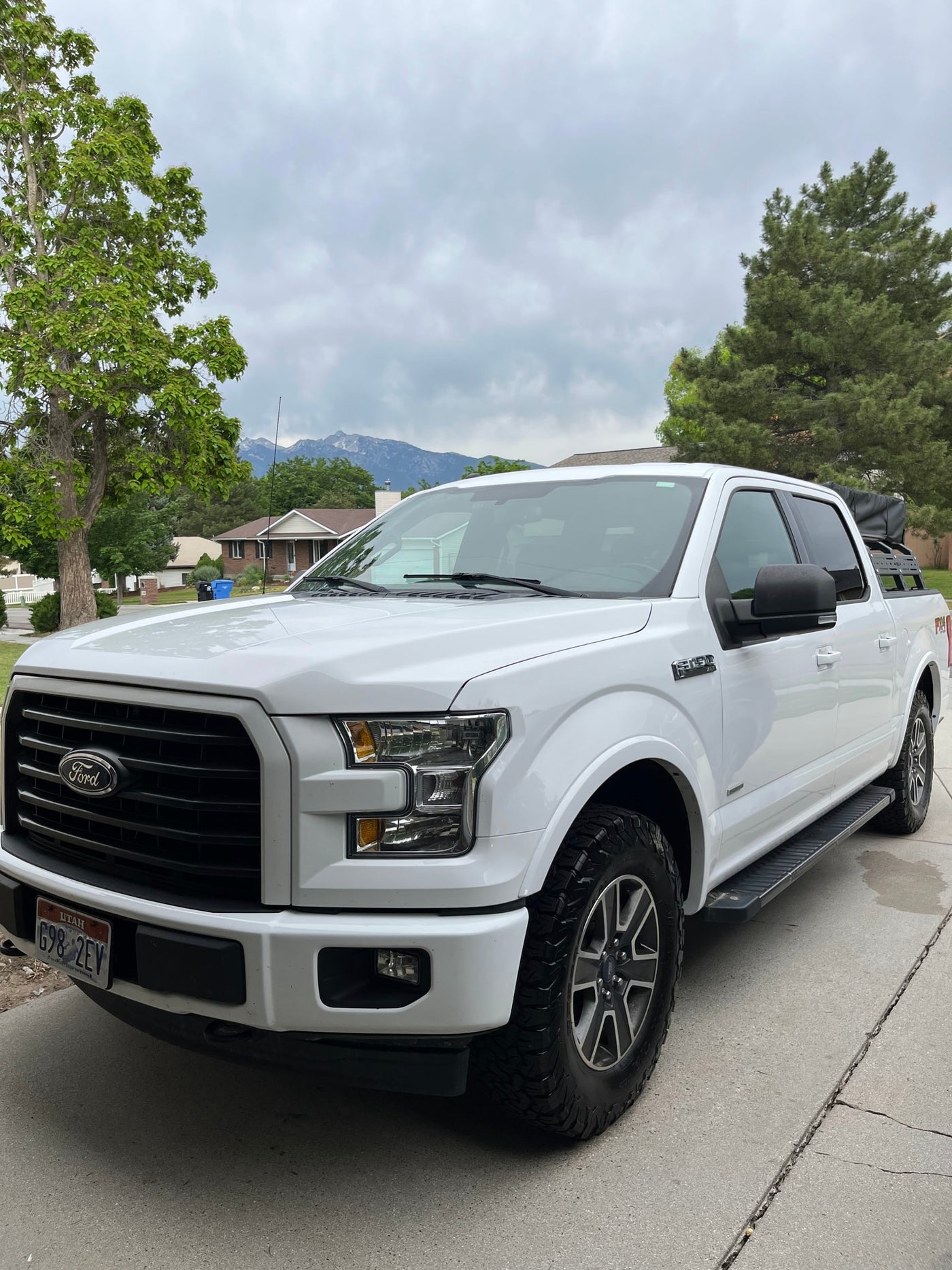 White Ford F-150 truck with rooftop tent for adventure travel. Consider an RV rental for your next outdoor trip. — photo 9