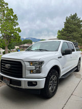 White Ford F-150 truck with rooftop tent for adventure travel. Consider an RV rental for your next outdoor trip.