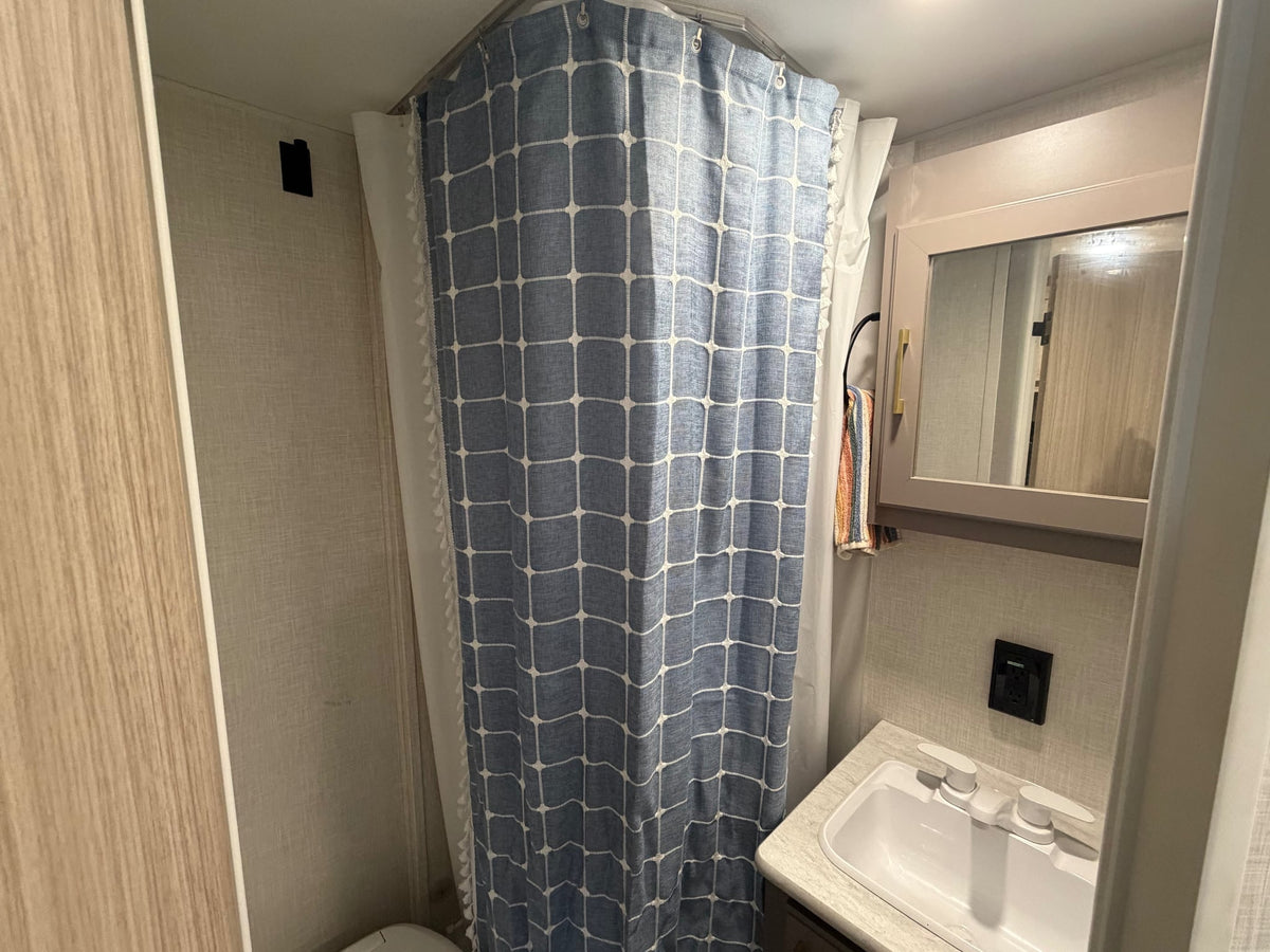  and a comfortable striped bed with a green blanket.|RV rental kitchen: gray cabinets — photo 20