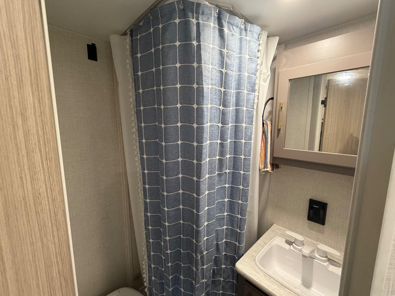  and a comfortable striped bed with a green blanket.|RV rental kitchen: gray cabinets — photo 20