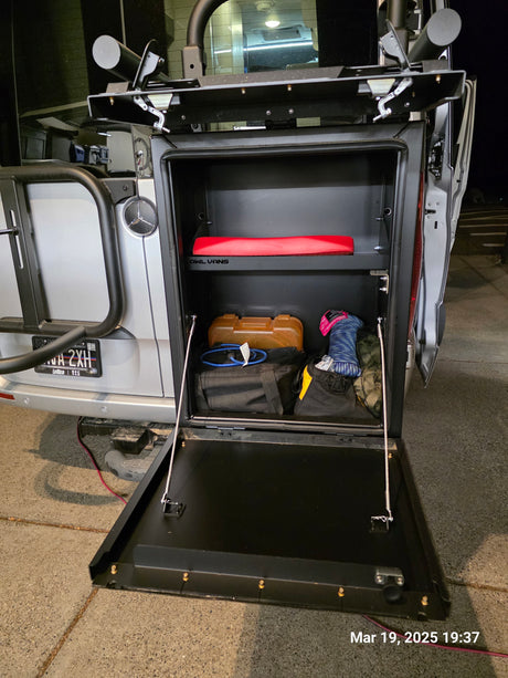 Owl Vans rear storage box open on a Sprinter van, perfect for an RV rental. Organized gear inside for adventure trips.