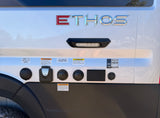 Ethos RV rental's utility panel, showing inputs for cable/sat, city water, shore power, and solar hookups, plus safety warnings.